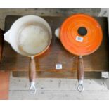 Two orange Le Creuset iron saucepans and a large ice bucket
