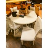 An oval cream extending dining table with fold away centre leaf with four matching cane backed