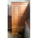 A modern pine two door wardrobe on draw base,