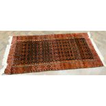 A red and patterned Bokhara rug,