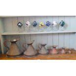 A set of six graduated copper measuring jugs