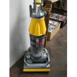 A yellow and silver Dyson upright vacuum cleaner