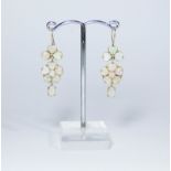 A pair of yellow gold and opal drop earrings in a floral design, stamped 9ct on one earring,