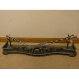 A Victorian decorative iron fire fender complete with three fire implements,