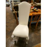 A set of four modern white high backed faux leather dining chairs