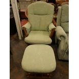 A rocking wood framed fireside chair with green covering and a marching foot stool,