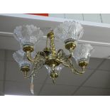 A five branch brass electric light pendent with glass shades and a three branch decorative metal