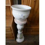 A floral decorated china jardiniere with matching pedestal