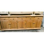 A long bow modern pine sideboard, fitted five drawers and cupboards,