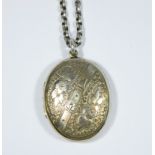 A Victorian oval silver locket and chain with flowers and strap engraved on the front and entwined
