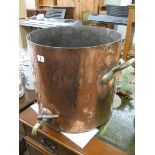 A very heavy large copper pot with brass tap and handles