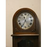 A 1930's oak and glazed case grandfather clock with circular silver dial