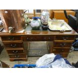 A reproduction yew wood twin pedestal desk fitted nine drawers with green leather top,