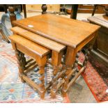 A nest of three oak coffee tables on barley twist legs