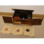 An early 20th Century wind up table model gramophone in mahogany case and a quantity of 78 records