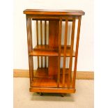 An inlaid yew wood three tier revolving bookcase,