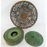 A Chinese green patterned bronze circular ashtray with cover and a pierced cast iron dish after the