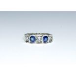 An Art Deco five stone diamond and sapphire ring set in white metal, ring size O,