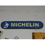 A long oval cast iron wall hanging Michelin sign