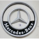 A circular cast iron wall hanging Mercedes Benz plate,