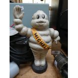 A waving Michelin man standing on a tyre