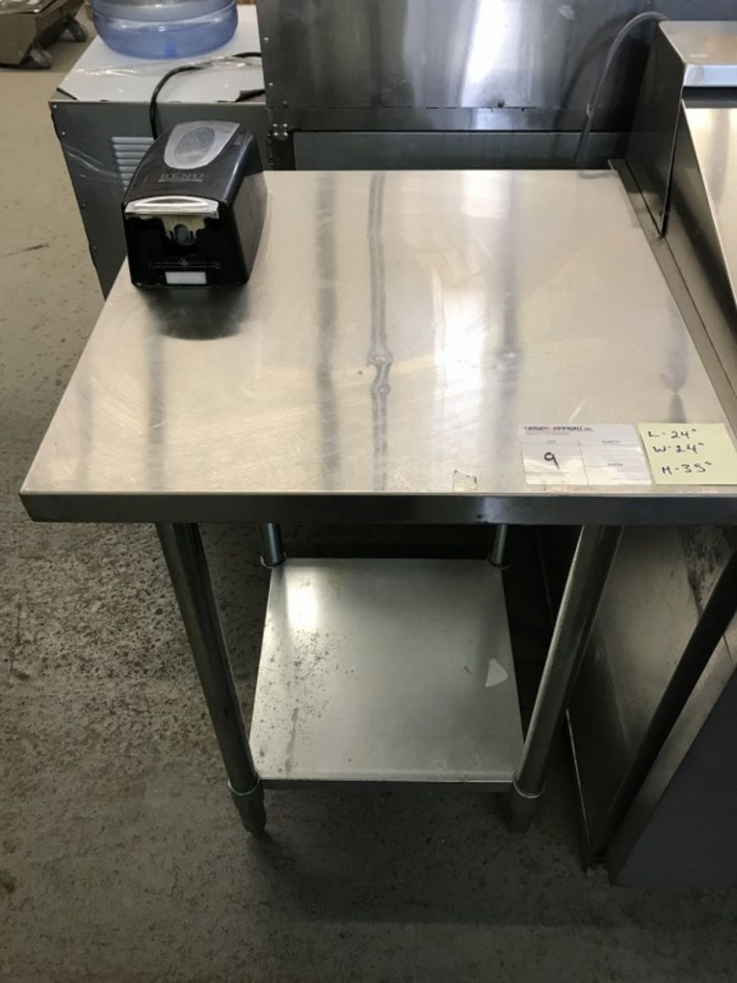 STAINLESS STEEL TABLE WITH BOTTOM SHELF AND ATTACHED RENU DISPENSER. 24"L X 24"W X 35"H