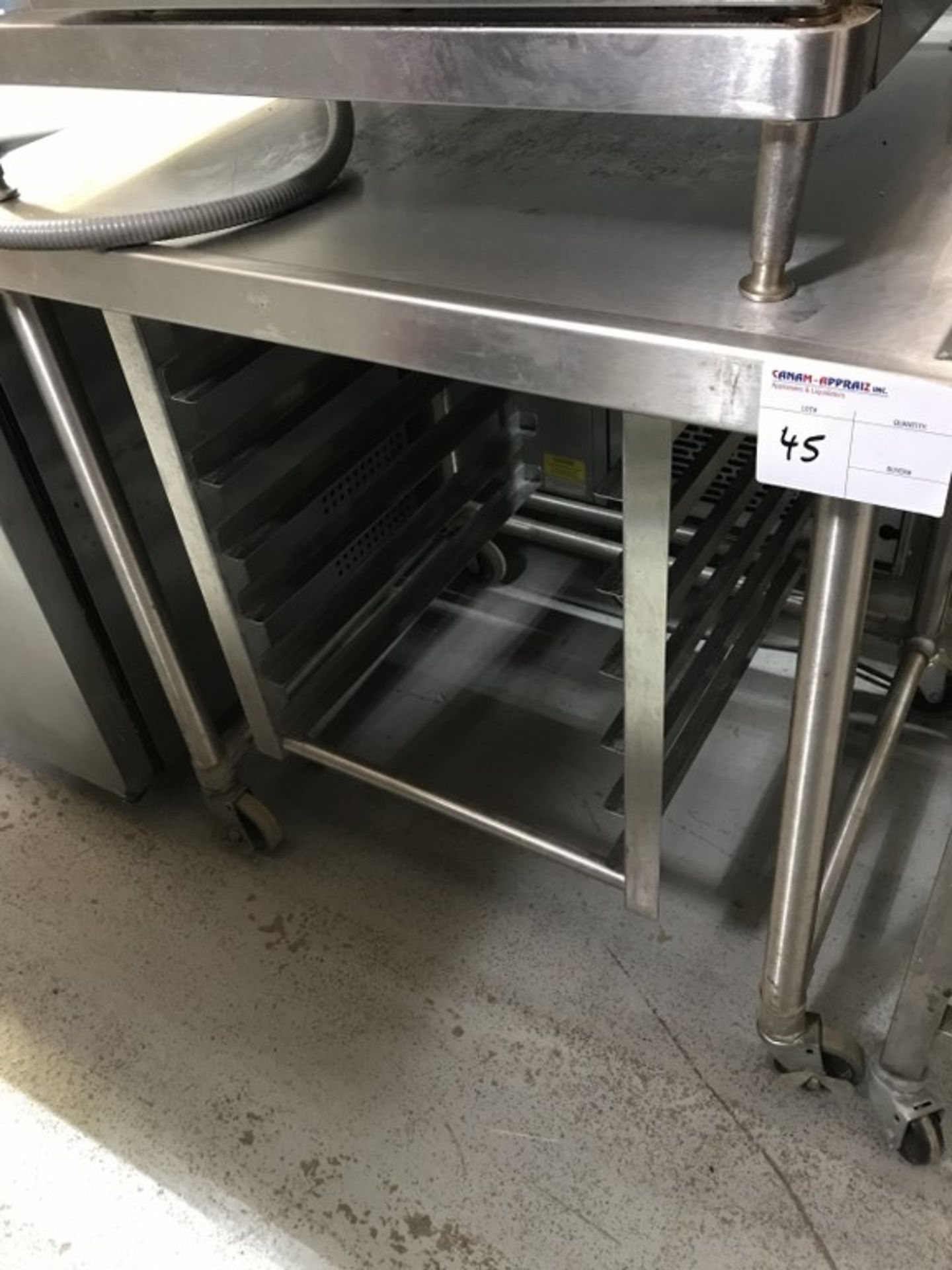 STAINLESS STEEL TABLE WITH TRAY RACK ON CASTERS