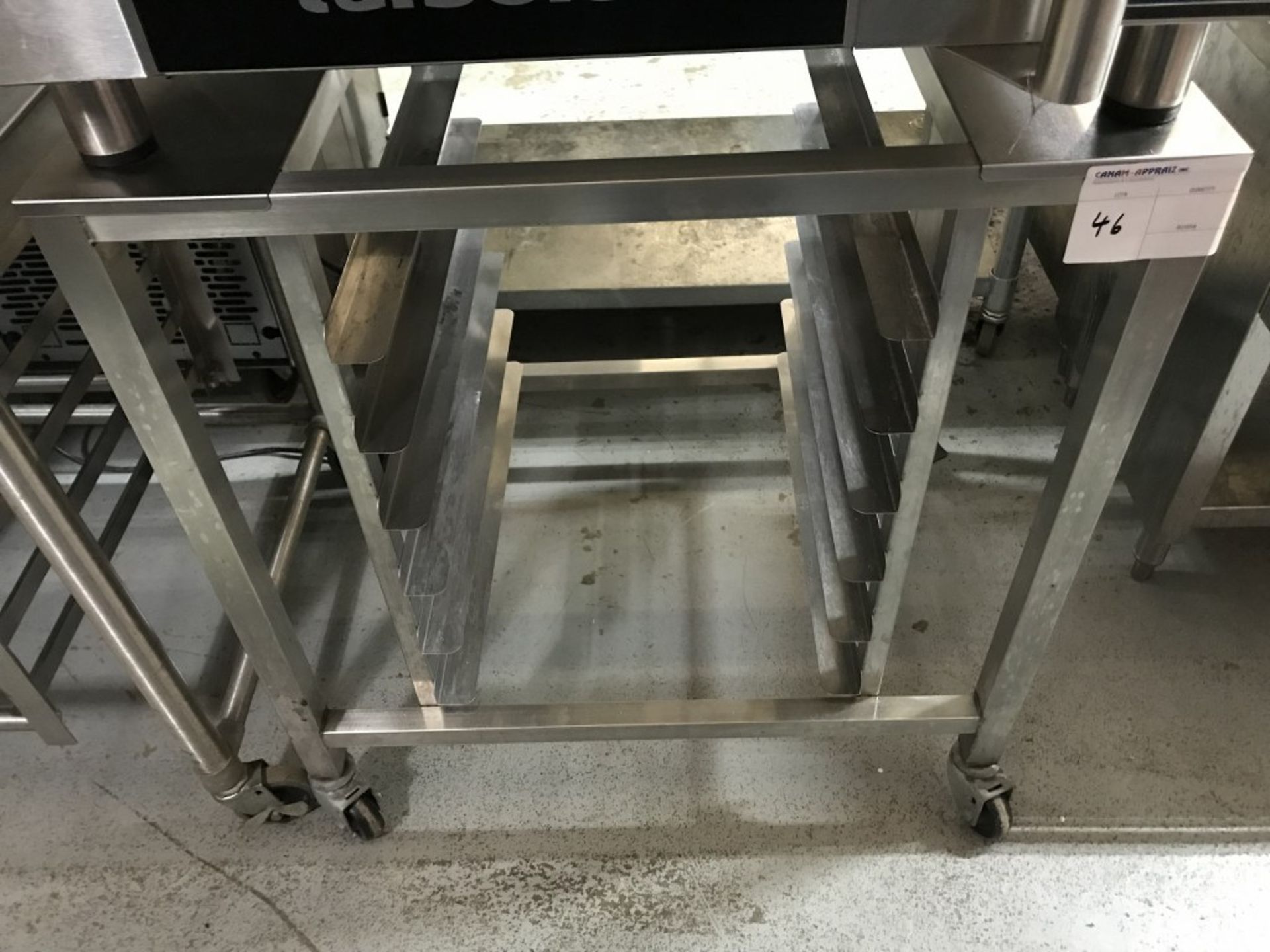 STAINLESS STEEL TABLE WITH TRAY RACK ON CASTERS