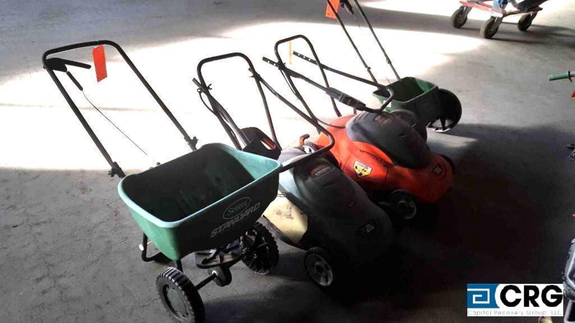 Lot of assorted electric lawn mowers and spreaders. Mowers are Black and Decker, spreaders are