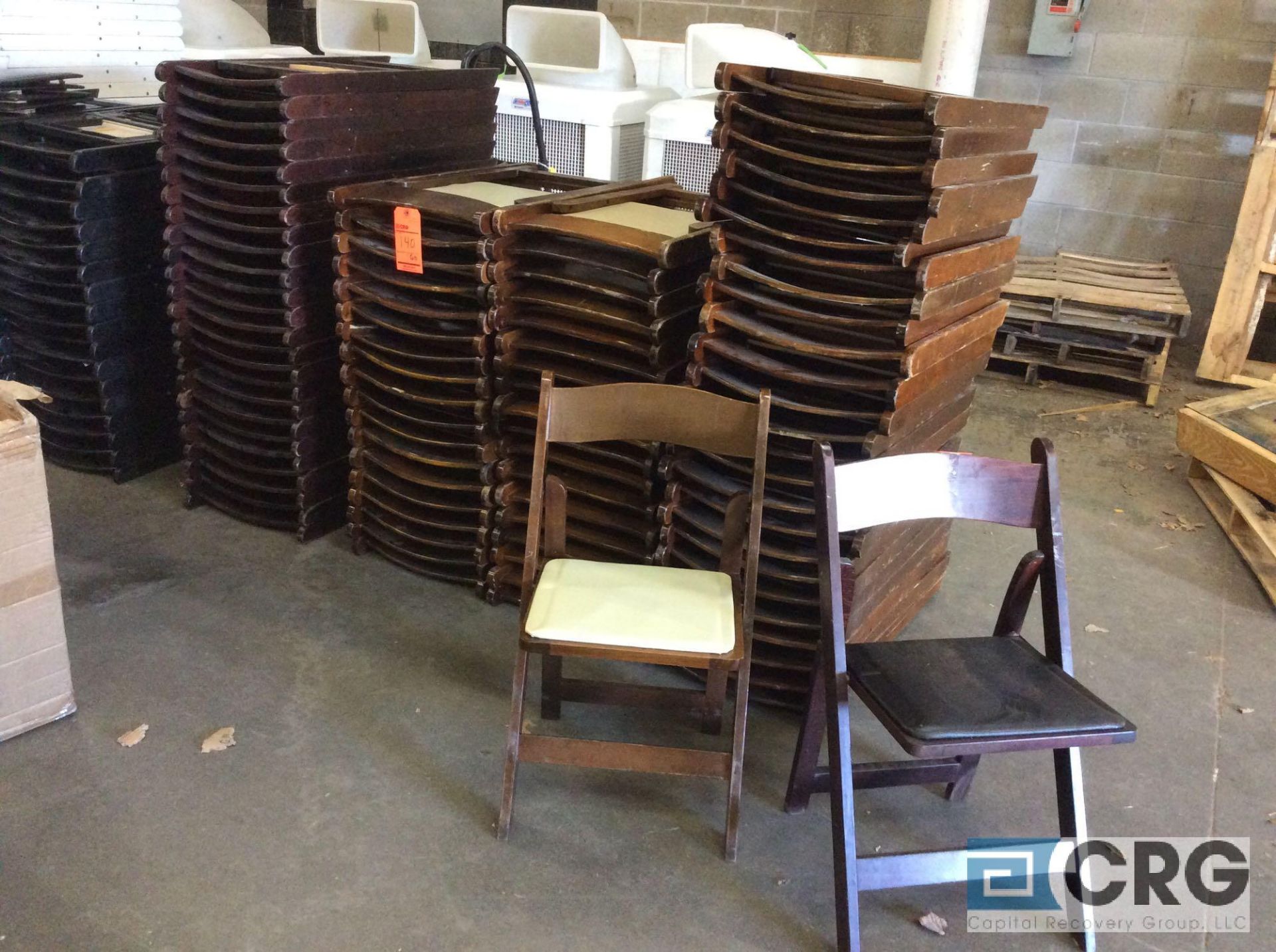 Lot of (85) assorted brown wood folding chairs, (60) with tan pads, and (25) with black pads.