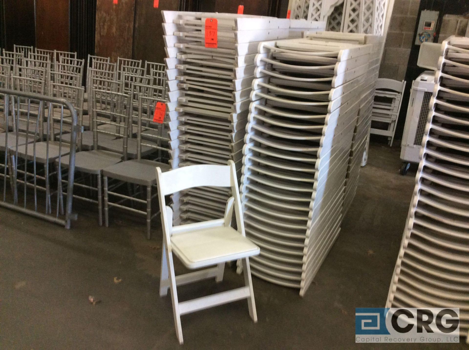 Lot of (100) assorted white resin folding chairs.