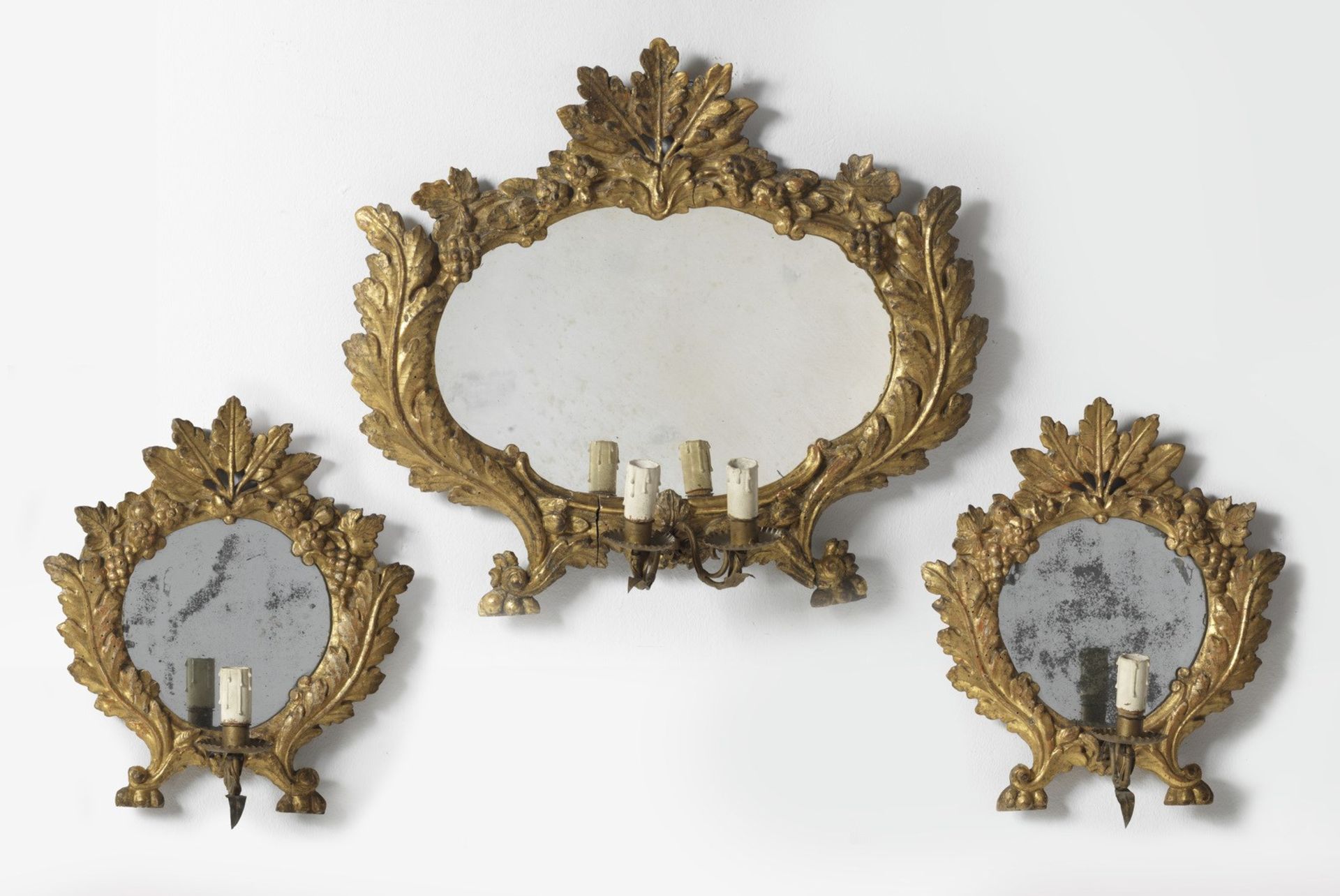 MANIFATTURA ITALIANA DEL XVIII SECOLO Group of three carved and gilded mirrors with leafy motif.