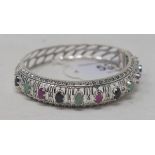 A silver, ruby, emerald and sapphire bangle Modern