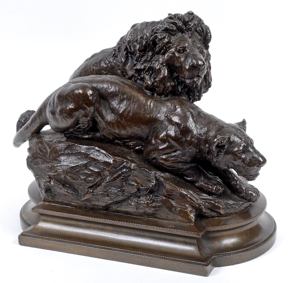 A bronze group of a lion and a lioness, on a rocky mound, indistinctly signed, 29 cm high See