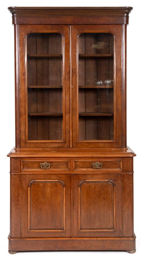A late Victorian walnut bookcase on cupboard having a pair of glazed doors above two frieze drawers,