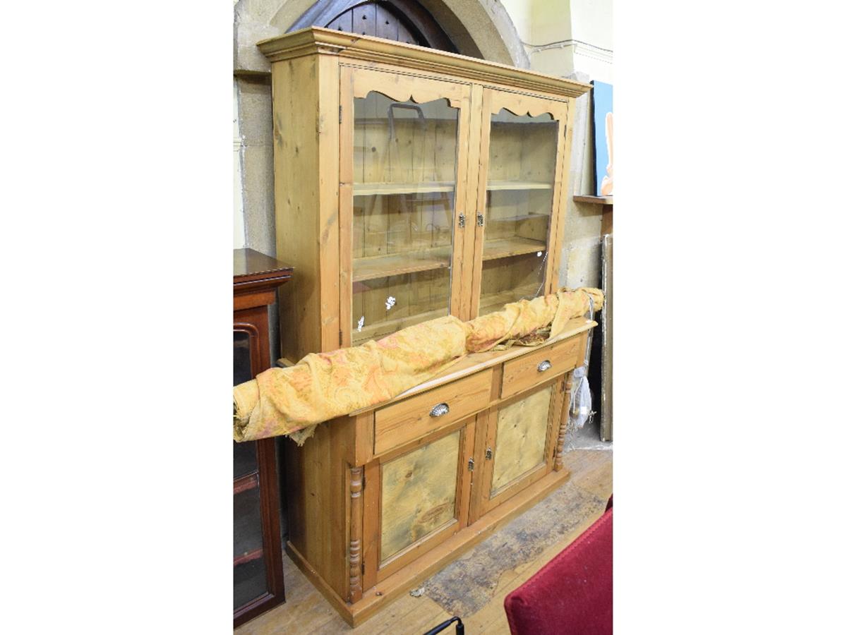 A pine kitchen dresser, with a pair of glazed doors above two frieze drawers and a pair of panel