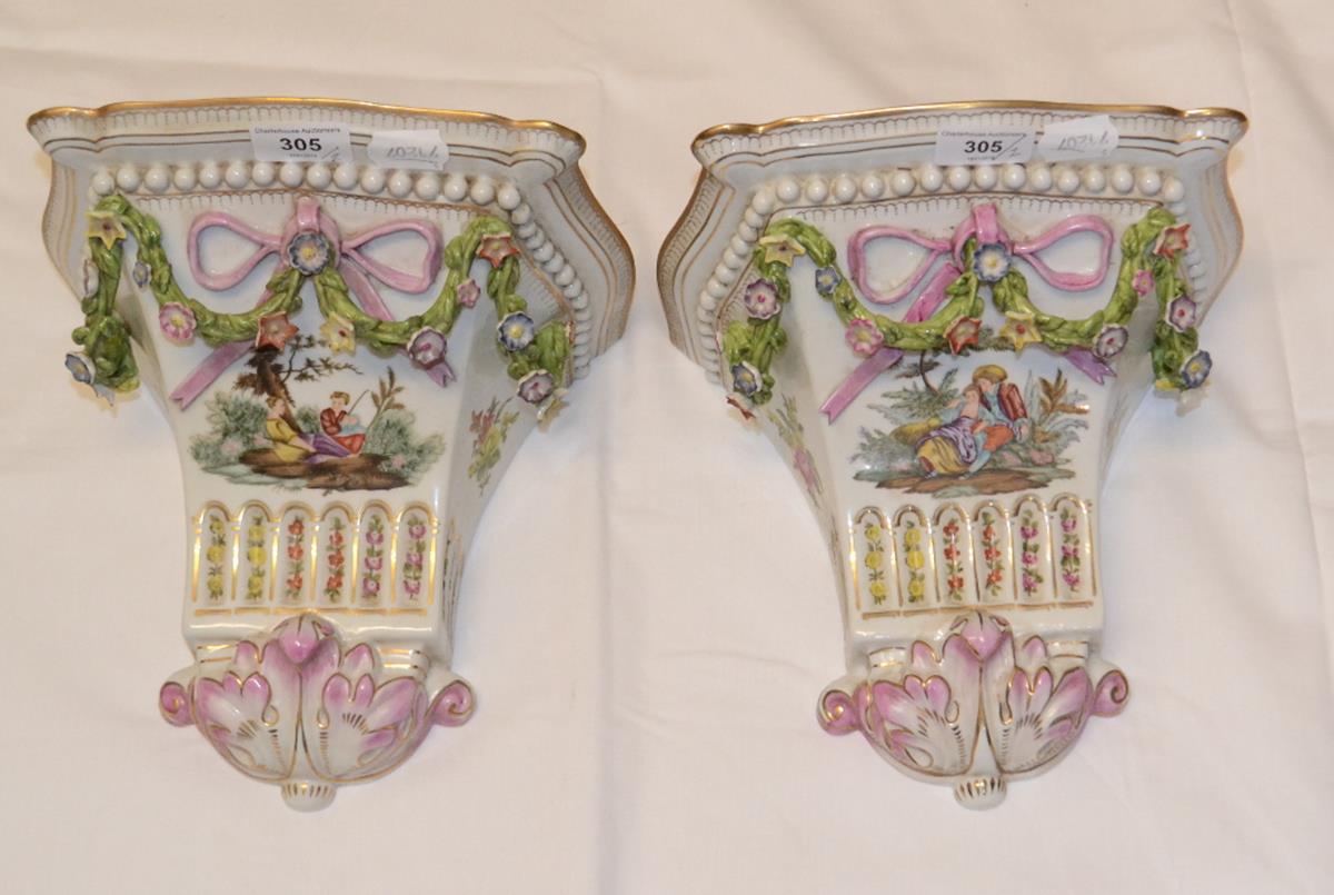 A pair of Meissen style porcelain wall brackets, decorated figures and foliage, 22.5 cm high (2)
