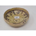 An Indian pottery bowl, decorated scrolls in manganese, restored, 18 cm diameter