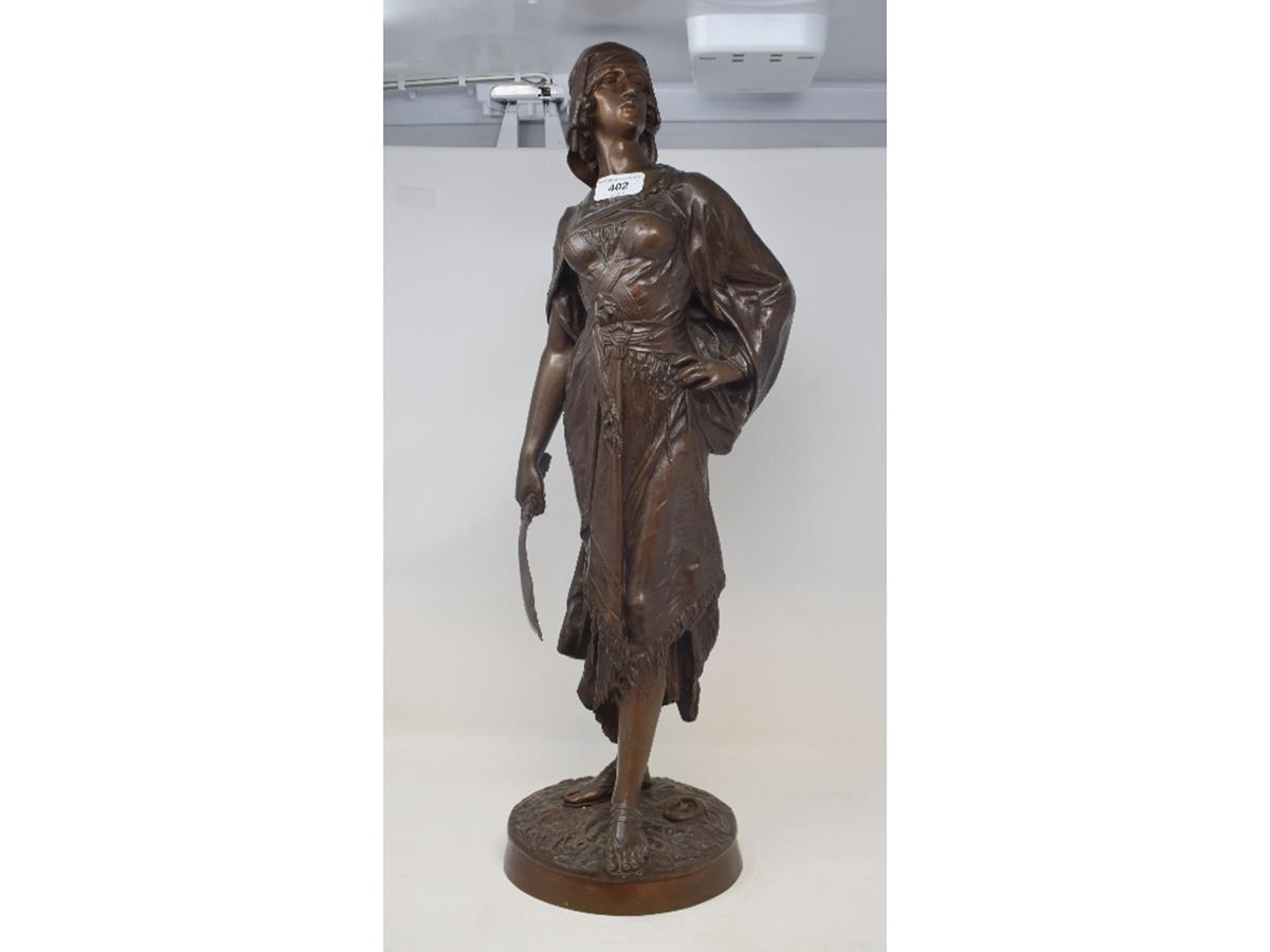 A late 19th/early 20th century bronze figure, of a lady carrying a scimitar sword, on a circular
