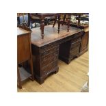 A yew wood partner's desk, with an arrangement of eleven drawers and two panel doors, 153.5 cm wide