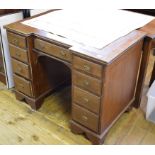 An Edwardian inlaid mahogany desk, of inverted breakfront form, the leatherette inset top above an