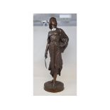 A late 19th/early 20th century bronze figure, of a lady carrying a scimitar sword, on a circular