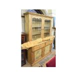 A pine kitchen dresser, with a pair of glazed doors above two frieze drawers and a pair of panel