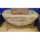 A large elm oval drop leaf table, on turned legs, in need of restoration, 151 cm diameter