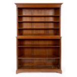 A late Victorian walnut open bookcase, having molded and dentil corners above an arrangement of