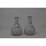 A Chinese porcelain Blanc de Chine vase, applied dragon, 20 cm high, and its pair (2)