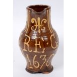 A slipware jug, with fleur-de-lys style motif and linear decoration, bears a motto FEARE GOD 1630,