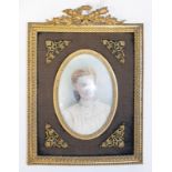 An oval bust portrait miniature, of a lady wearing a lace blouse, watercolour, 9 x 6 cm, in an