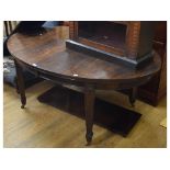 An Edwardian mahogany oval extending dining table, inset two extra leaves, on tapering leaf carved