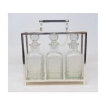 A Dr Christopher Dresser style three bottle tantalus, 27 cm high Modern Report by RH No the tantalus